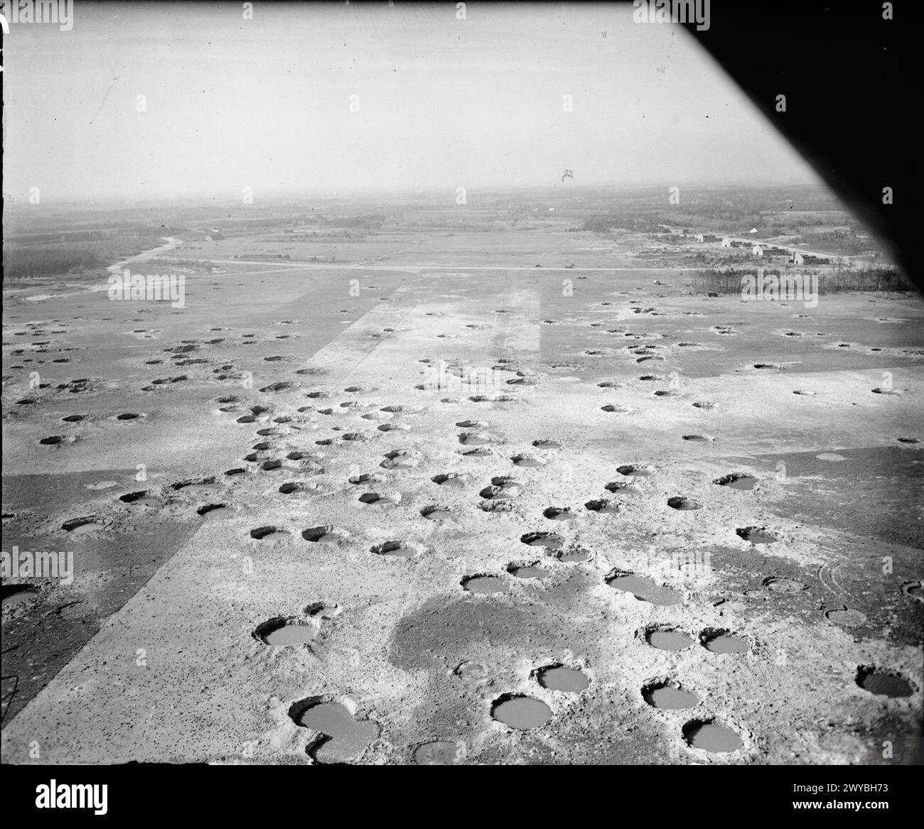 Vista aerea obliqua dell'aeroporto B106/Twente, Enschede, Paesi Bassi, che mostra piste danneggiate da bombe dopo la cattura da parte delle forze alleate. I Supermarine Spitfire del No. 125 Wing divennero operativi il 7 aprile 1945, volando dalla striscia di erba durante le operazioni della 2nd Tactical Air Force. Foto Stock