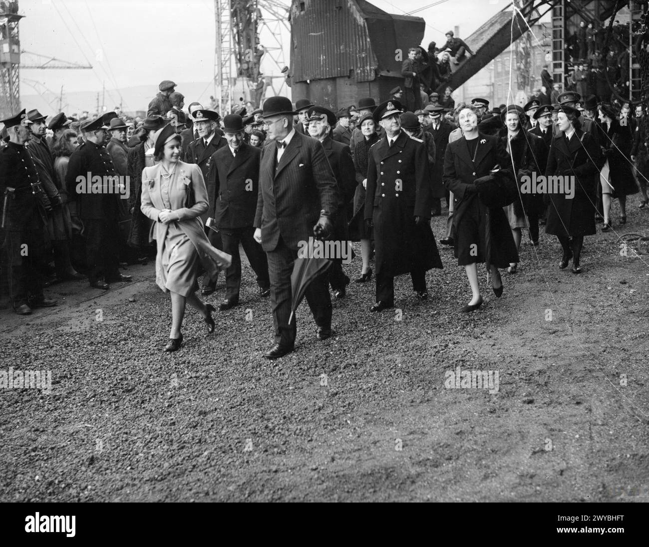 LA PRINCIPESSA ELISABETTA LANCIA LA PIÙ GRANDE NAVE DA GUERRA DELLA GRAN BRETAGNA. 30 NOVEMBRE 1944, CLYDEBANK. LA PRINCIPESSA ELIZABETH LANCIÒ LA HMS VANGUARD, LA PIÙ GRANDE NAVE DA GUERRA MAI COSTRUITA NELLE ISOLE BRITANNICHE. - La Principessa Elizabeth parla con un funzionario mentre cammina attraverso il cantiere affollato all'arrivo. , Foto Stock