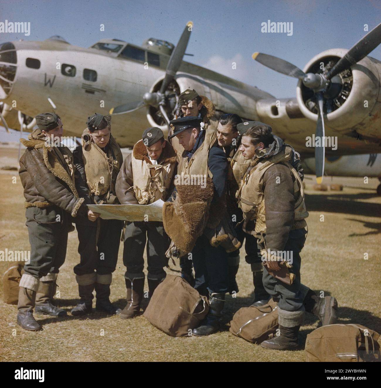 COMANDO COSTIERO DELLA ROYAL AIR FORCE, 1939-1945. - Un colpo pubblicitario che vuole mostrare al capitano di un Boeing Fortress Mark II del comando costiero di tenere una conferenza finale con il suo equipaggio prima di decollare. La fotografia è stata scattata a Benbecula nelle Ebridi esterne di fronte a una fortezza Mark II, FL462 'W' del No. 220 Squadron RAF. L'equipaggio era, infatti, un gruppo ad hoc proveniente dal No. 206 Squadron RAF, e il "capitano" (3° da destra, indossando il cappello SD) era il Flying Officer L W Taylor RAAF, un ufficiale delle pubbliche relazioni del Ministero dell'aria. , Royal Air Force, 220 Squadron, Royal Air Force, 206 Squadron, aria M Foto Stock