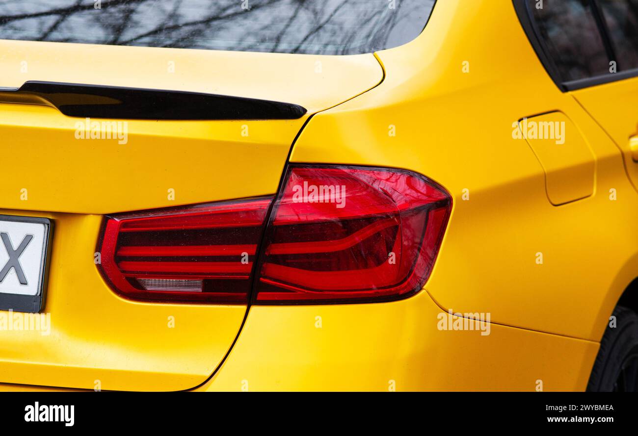 Kiev. Ucraina. Aprile 2024. Primo piano di un'auto BMW gialla. Lampadina a LED per luci posteriori di un'auto. la luce posteriore. Foto di alta qualità Foto Stock