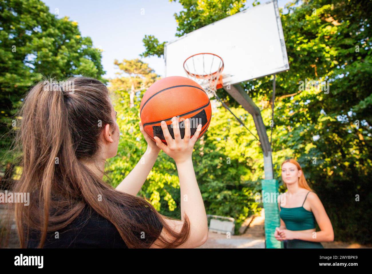Una ragazza sta tenendo in mano una pallacanestro e sta sparando durante una partita. Foto Stock