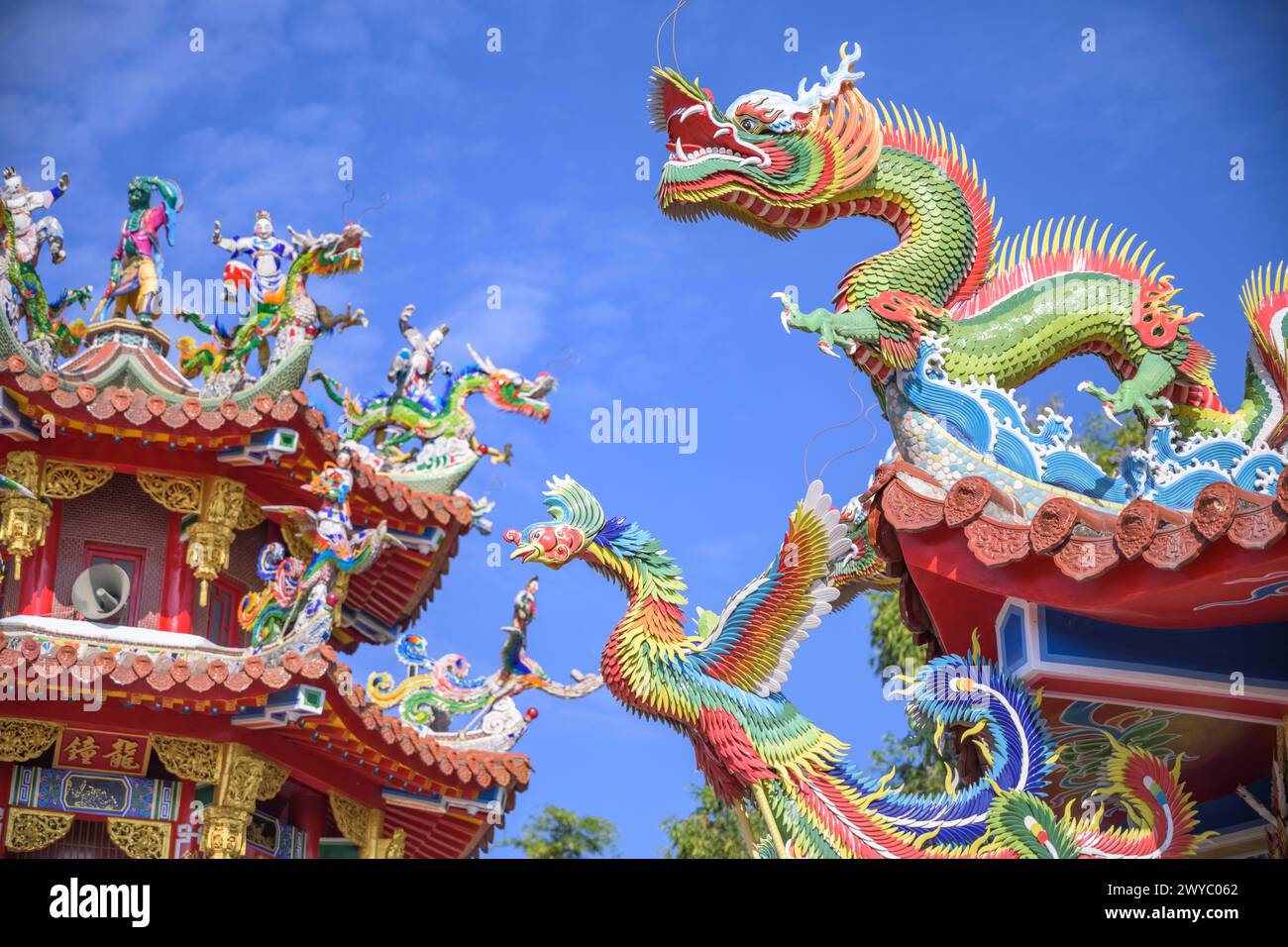 Colorate e intricate sculture di drago adornano il tetto di un tempio tradizionale taiwanese contro un cielo limpido Foto Stock