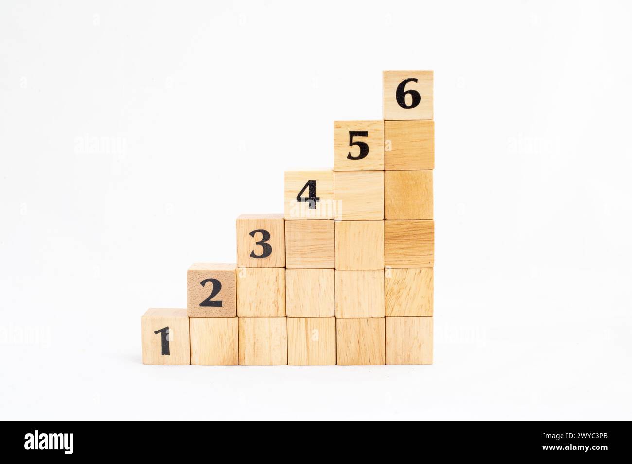 Blocchi di legno impilabili come gradini con numeri da 1 a 6 isolati su sfondo bianco. Processo di successo per la crescita dei concetti aziendali. Copia spazio. Foto Stock