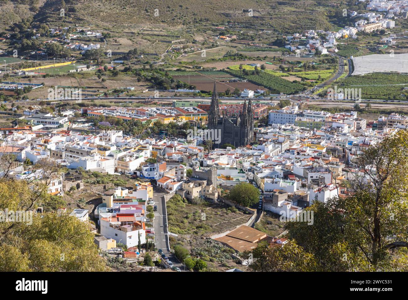 Guardando in basso da Montaña Arucas verso la città di Arucas con la distinta chiesa oscura (Parroquia) di San Juan Bautista. A nord dell'isola di Grand Canary, Cana Foto Stock