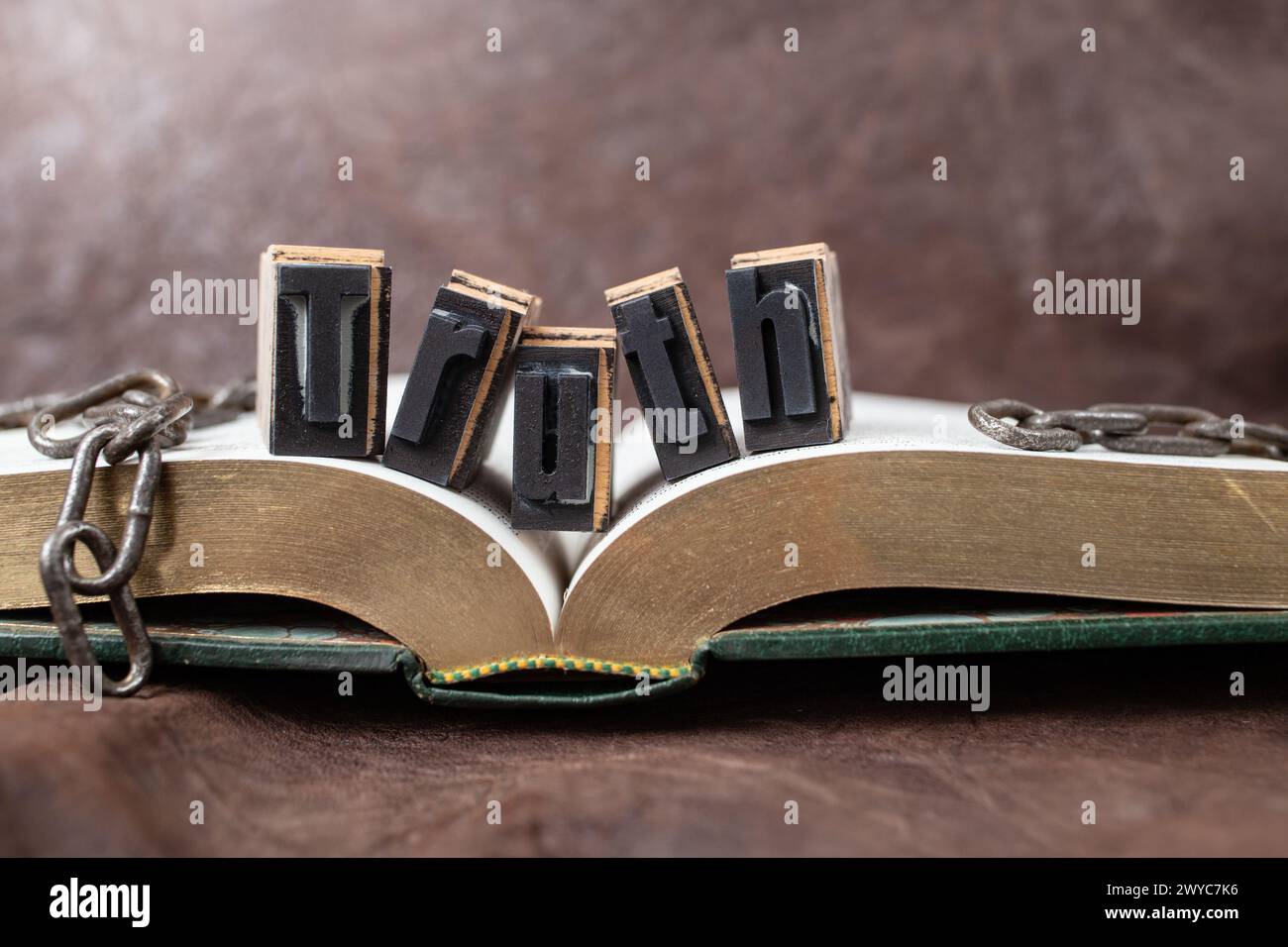 la verità ti renderà libero, concetto di natura morta con libro d'oro e catene rotte, messa a fuoco morbida Foto Stock