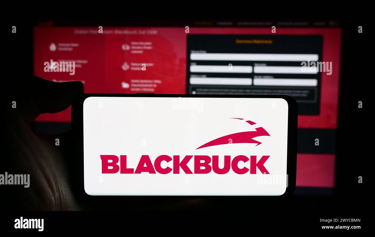 Persona che detiene un cellulare con il logo della società Zinka Logistics Solutions Pvt. Ltd (BlackBuck) davanti alla pagina Web. Mettere a fuoco il display del telefono. Foto Stock