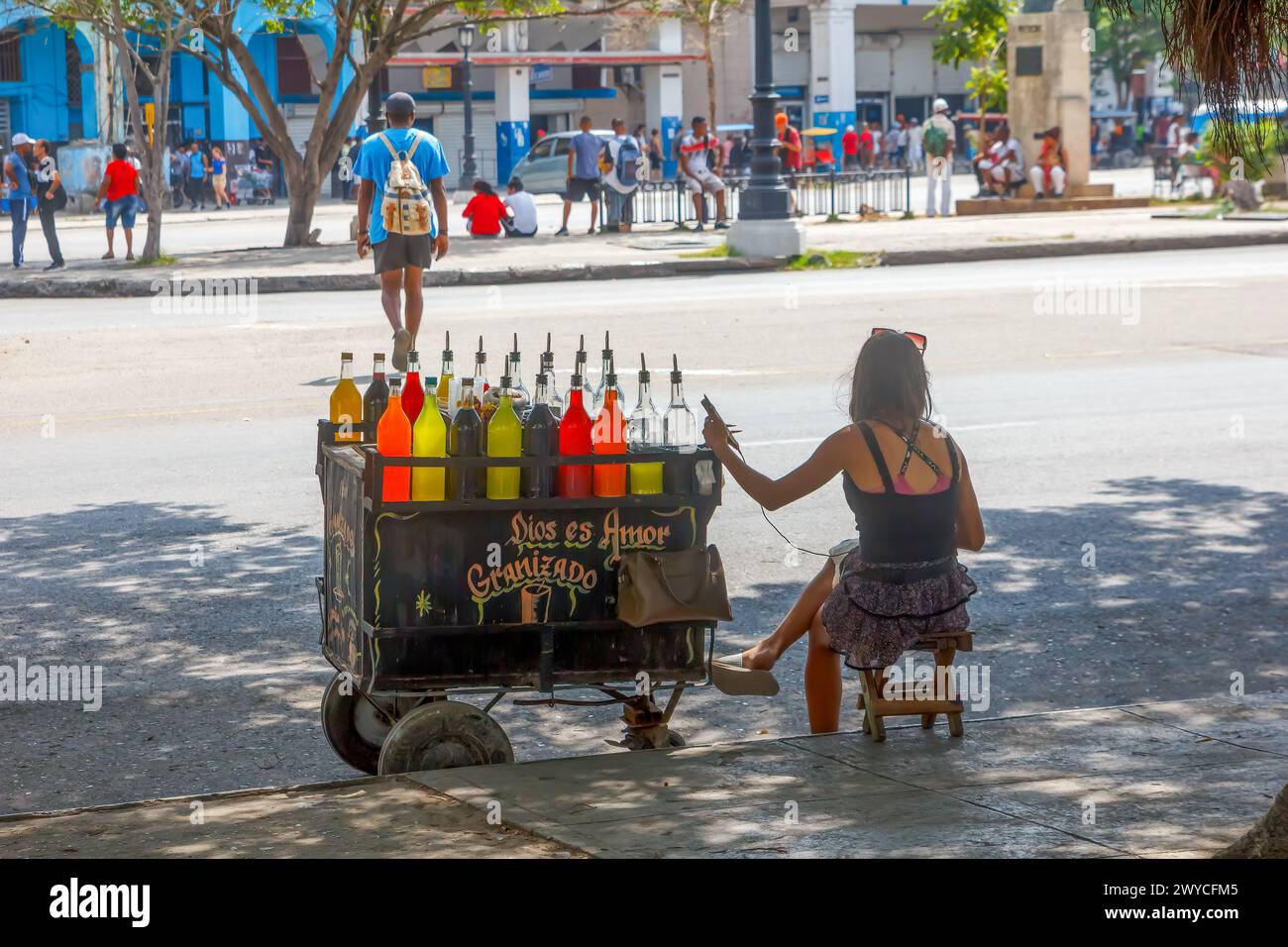 Donna cubana che vende ghiaccio aromatizzato su un'auto rustica, strada cittadina, stile di vita di altre persone a l'Avana, Cuba Foto Stock