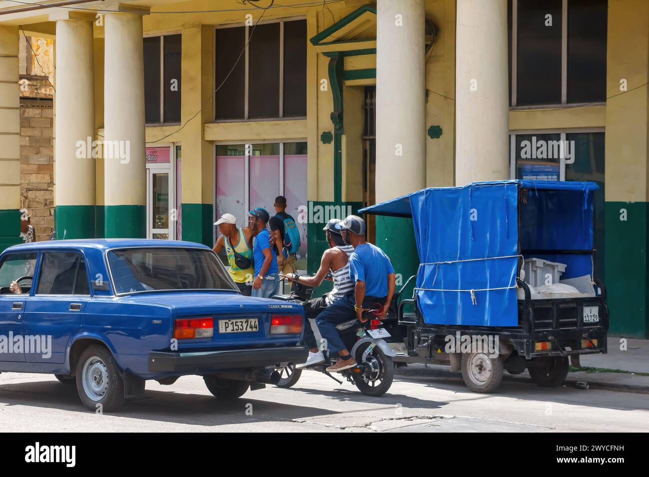 Due uomini cubani in moto, traffico cittadino e stile di vita a l'Avana, Cuba Foto Stock