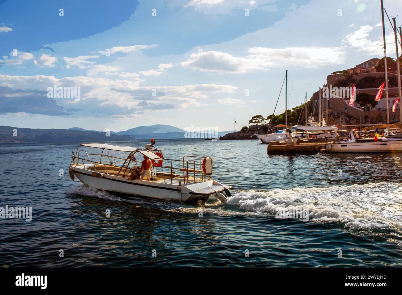 Barche a motore in movimento (taxi d'acqua o barca a remi) ad alta velocità nel Mar Mediterraneo - vista dall'isola greca di Idra in una fantastica ricreazione . Cann. Storico Foto Stock