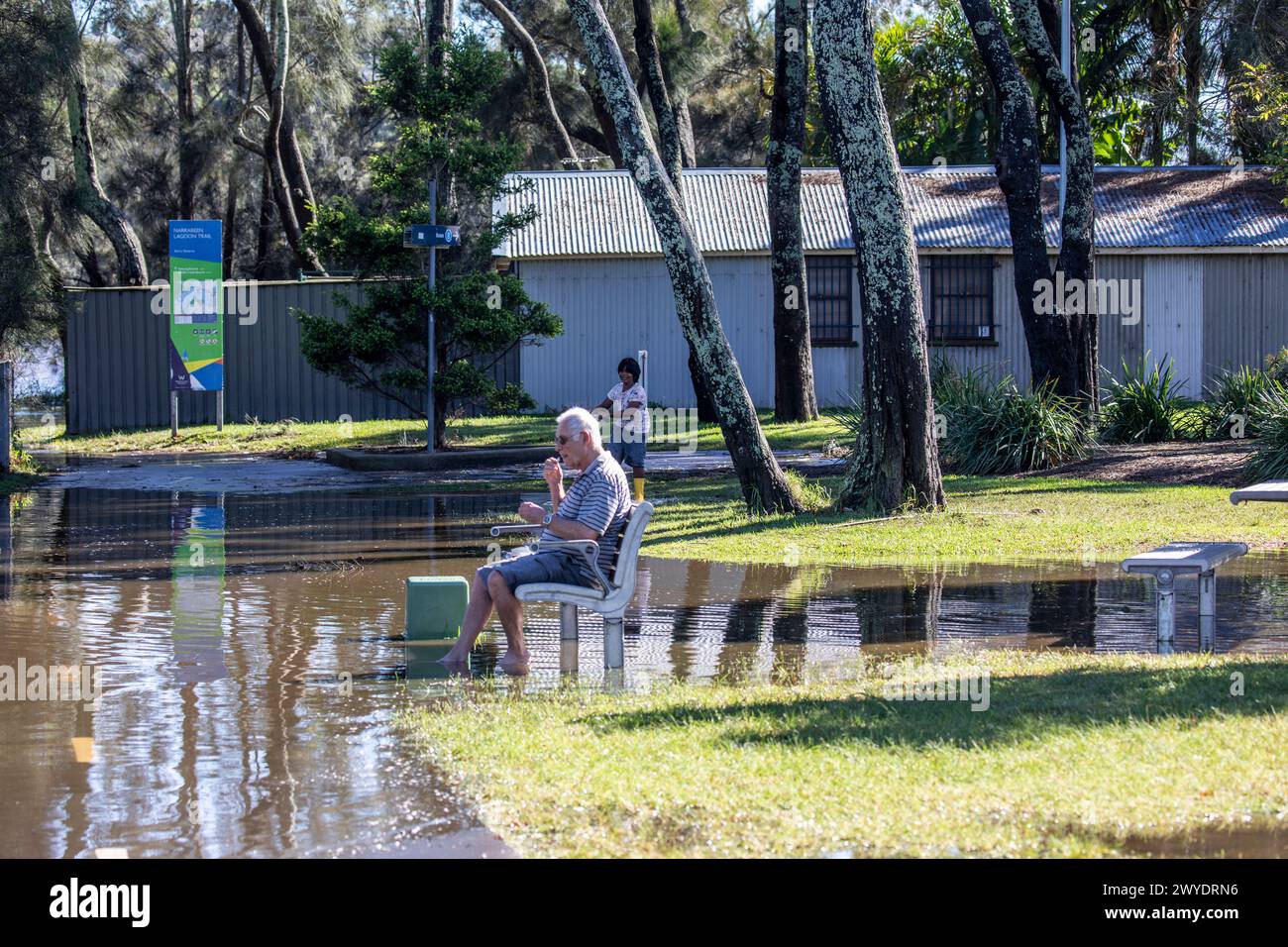 Sabato 6 aprile 2024. Sydney è stata colpita da un diluvio di pioggia nelle ultime 48 ore, con alcune aree, tra cui Penrith, che hanno ricevuto le piogge più pesanti di sempre, a Narrabeen i residenti intorno alla laguna di Narabeen, nella foto, sono stati invitati ad evacuare a causa dell'innalzamento del livello dell'acqua dal lago Narrabeen sulle spiagge settentrionali di Sydney. dove sono caduti oltre 150 mm di pioggia. Ci sono stati oltre 50 avvistamenti di inondazioni lungo i fiumi nel nuovo Galles del Sud e si prevede che la diga di Warragamba fuoriesca. Nella foto un anziano si siede sulla panchina del parco nelle acque alluvionali accanto al lago. Accreditate le notizie dal vivo di Martin Berry @alamy. Foto Stock