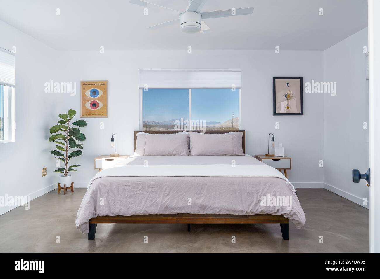 Moderna camera da letto bohémien color bianco con letto, comodino e pavimento in cemento lucido Foto Stock