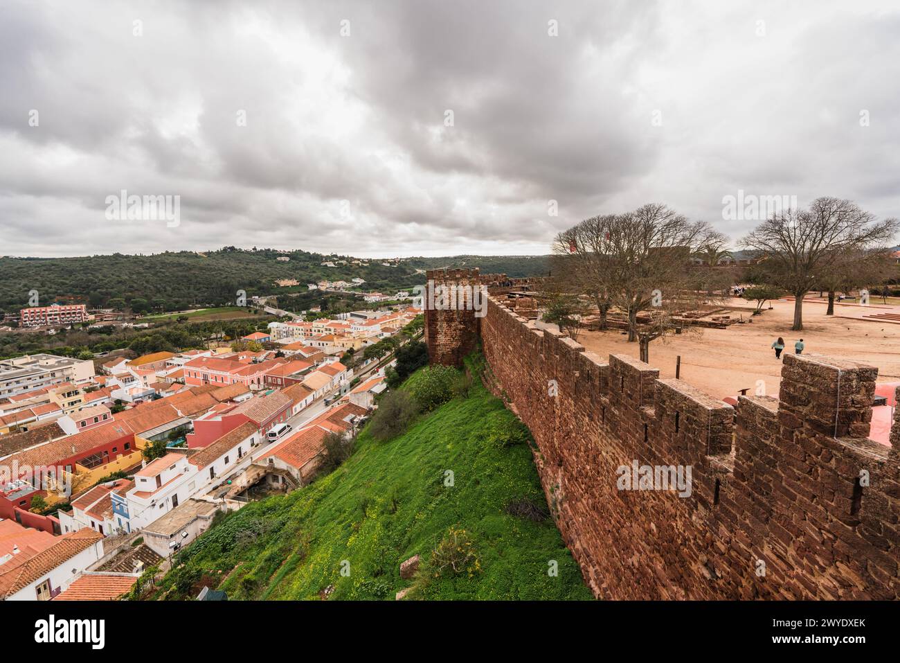 Affacciato sui tetti di terracotta di una città dalle antiche mura del Castello di Silves sotto un cielo spettacolare. Foto Stock