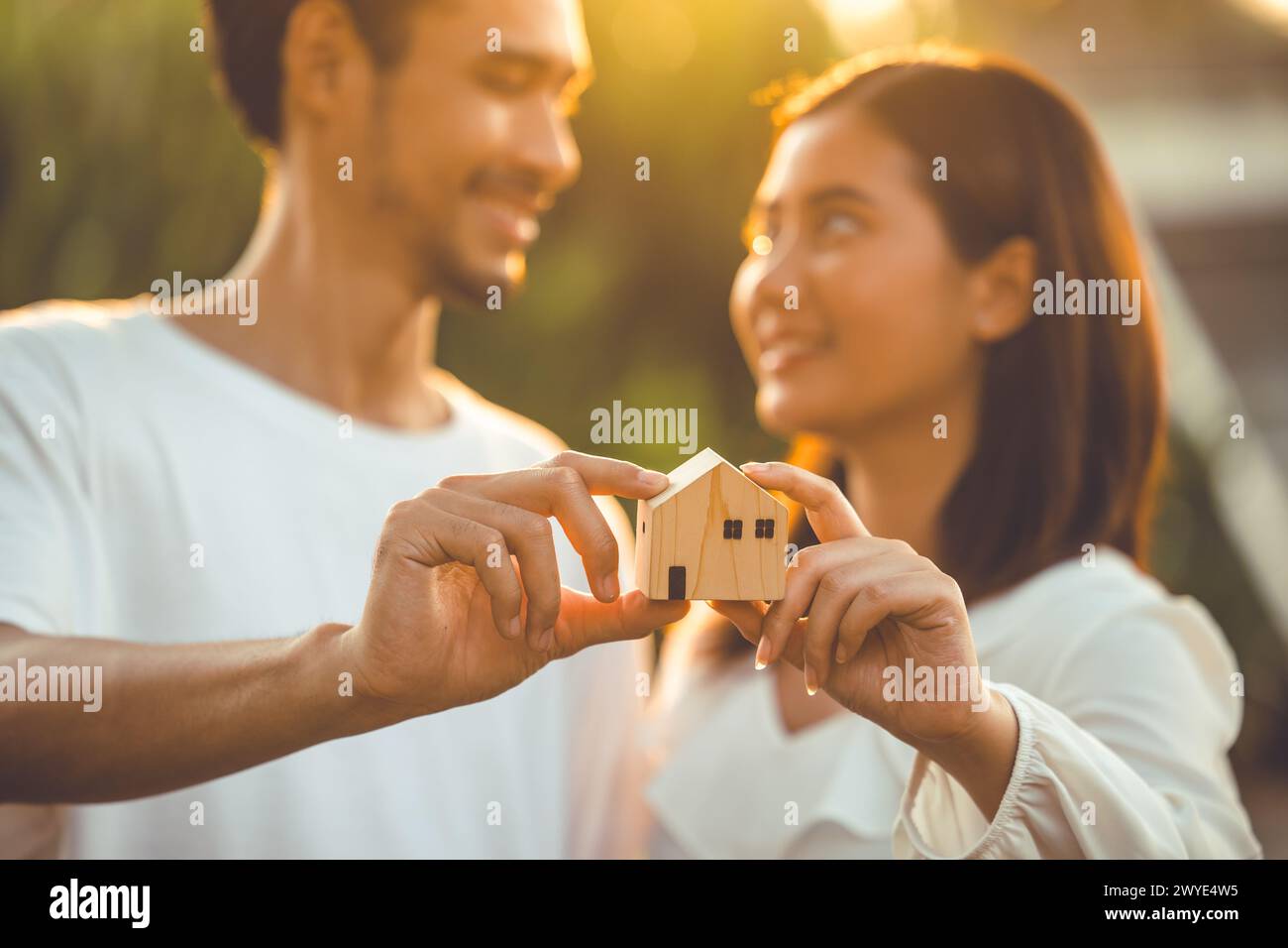 persone che tengono a mano il modello di casa in legno in miniatura per l'edilizia bancaria mutuo affitto immobiliare affitto casa concetto di famiglia Foto Stock