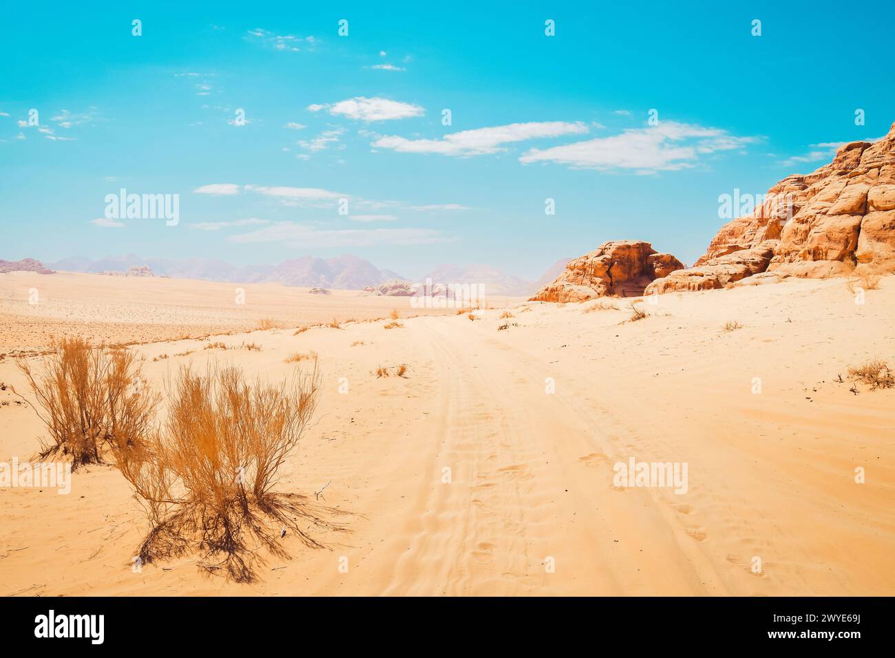 Panorama panoramico nel deserto del rum di Wadi nelle calde giornate di sole con piste per auto sulla sabbia. Famose location di film come Star Wars; The martian Foto Stock