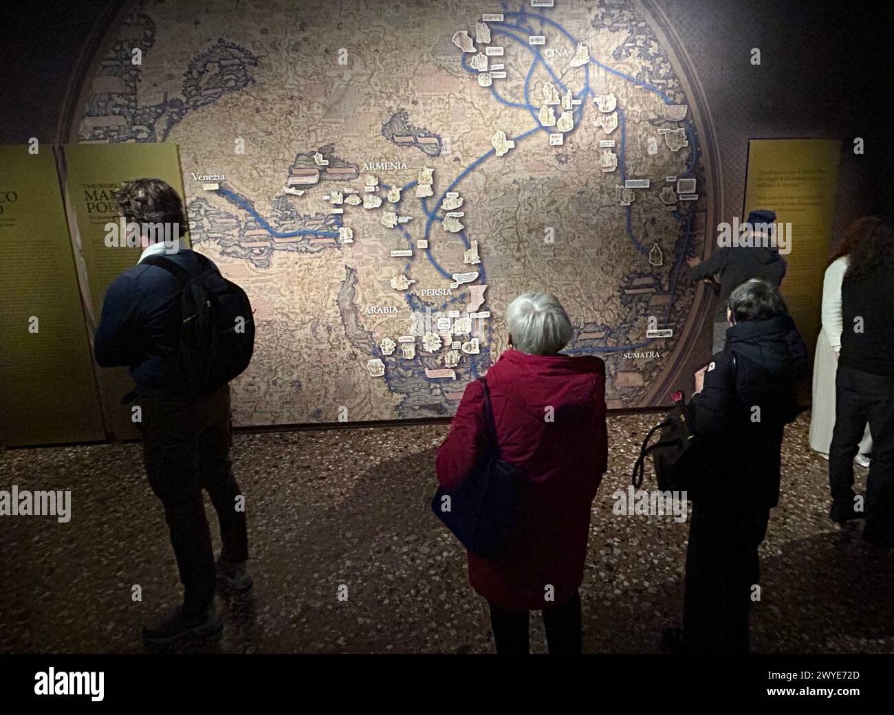 Venedig, Italia. 5 aprile 2024. I visitatori dello stand espositivo Marco Polo di fronte a una mappa che mostra il percorso di viaggio del commerciante. Venezia celebra il suo più famoso cittadino Marco Polo (presumibilmente 1254-1324) con una grande mostra in occasione del 700° anniversario della sua morte. Lo spettacolo, aperto il sabato e caratterizzato da reperti scavati, mappe e libri, può essere visto nel Palazzo Ducale fino a settembre 29. Crediti: Christoph Sator/dpa/Alamy Live News Foto Stock