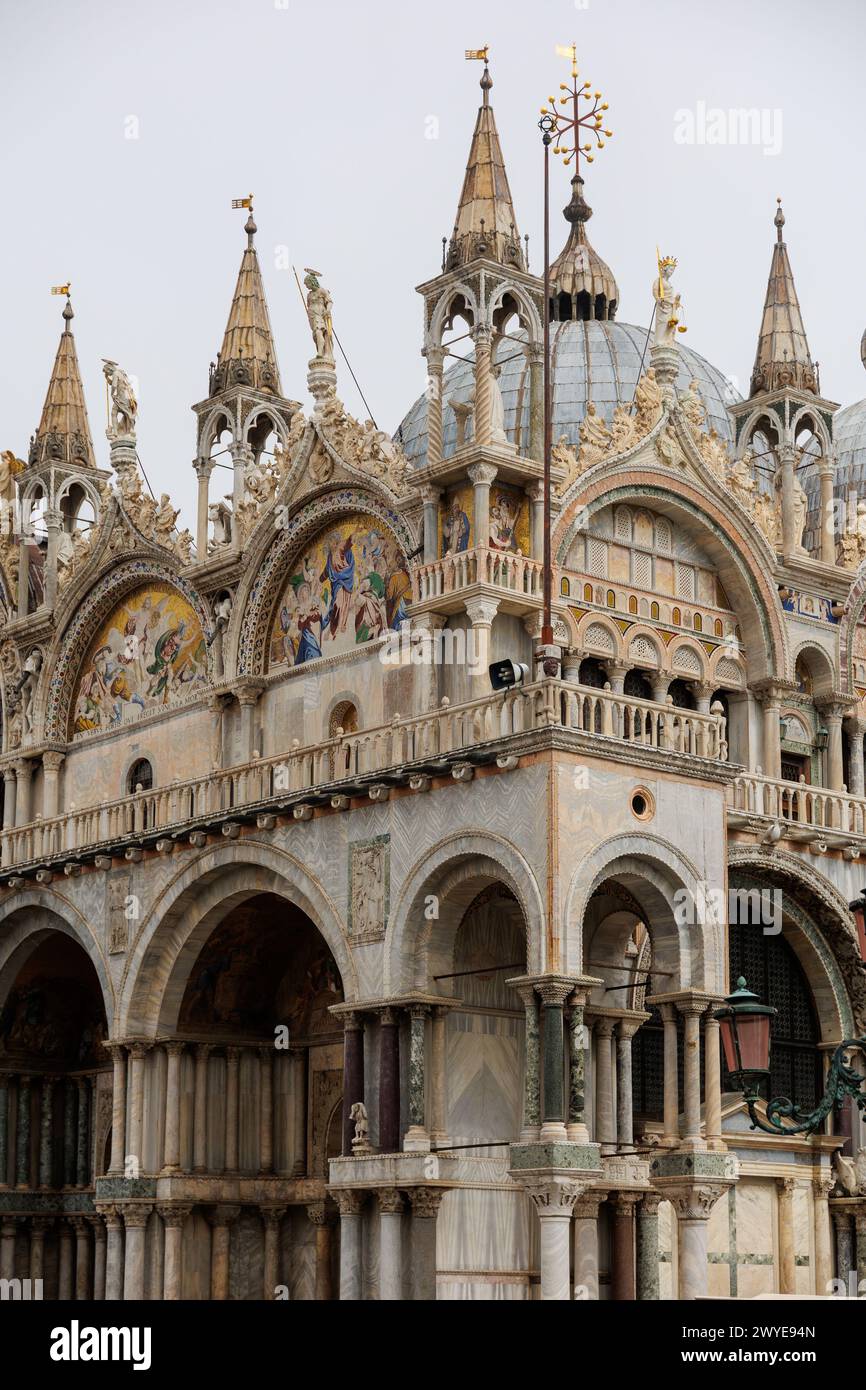 Un grandioso edificio medievale caratterizzato da una facciata simmetrica con arcata, la Basilica di San Marco e la Chiesa di Venezia Foto Stock