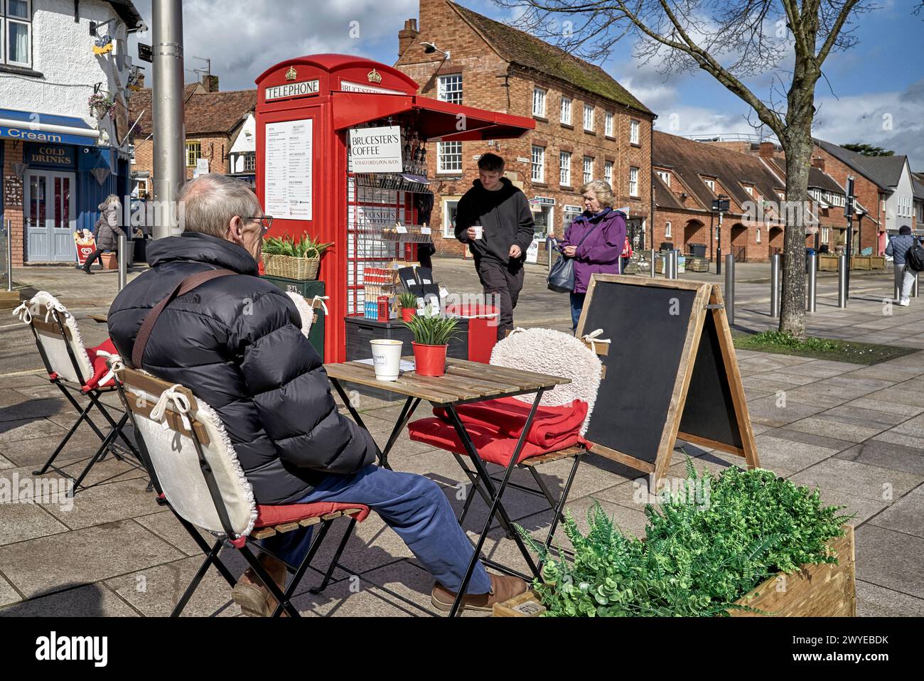 Uomo anziano seduto da solo ad un chiosco del caffè sul marciapiede. Inghilterra Regno Unito Foto Stock