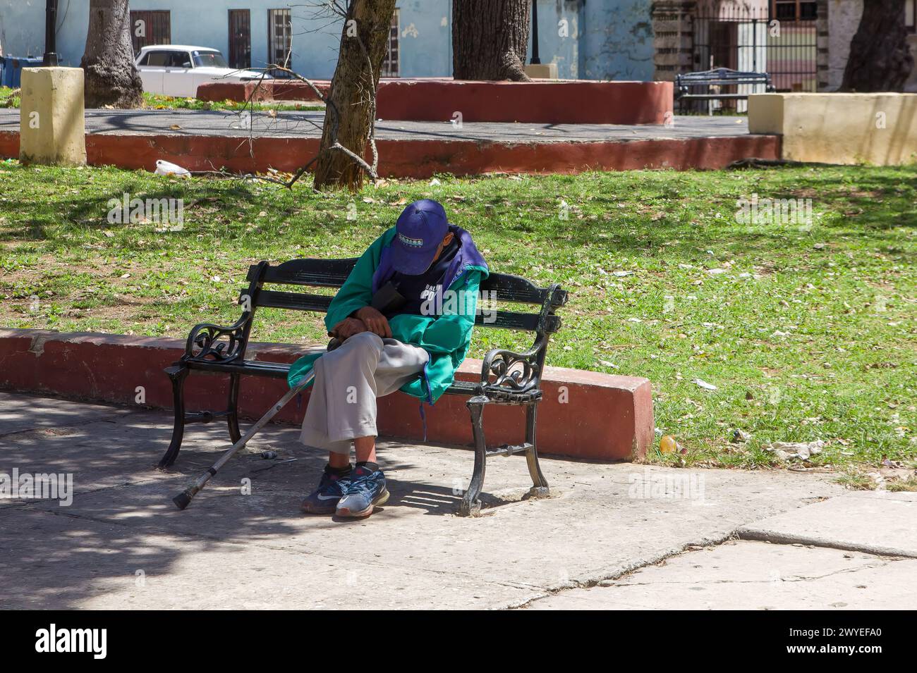 Anziano cubano che dorme su una panchina di piazza a l'Avana, Cuba Foto Stock
