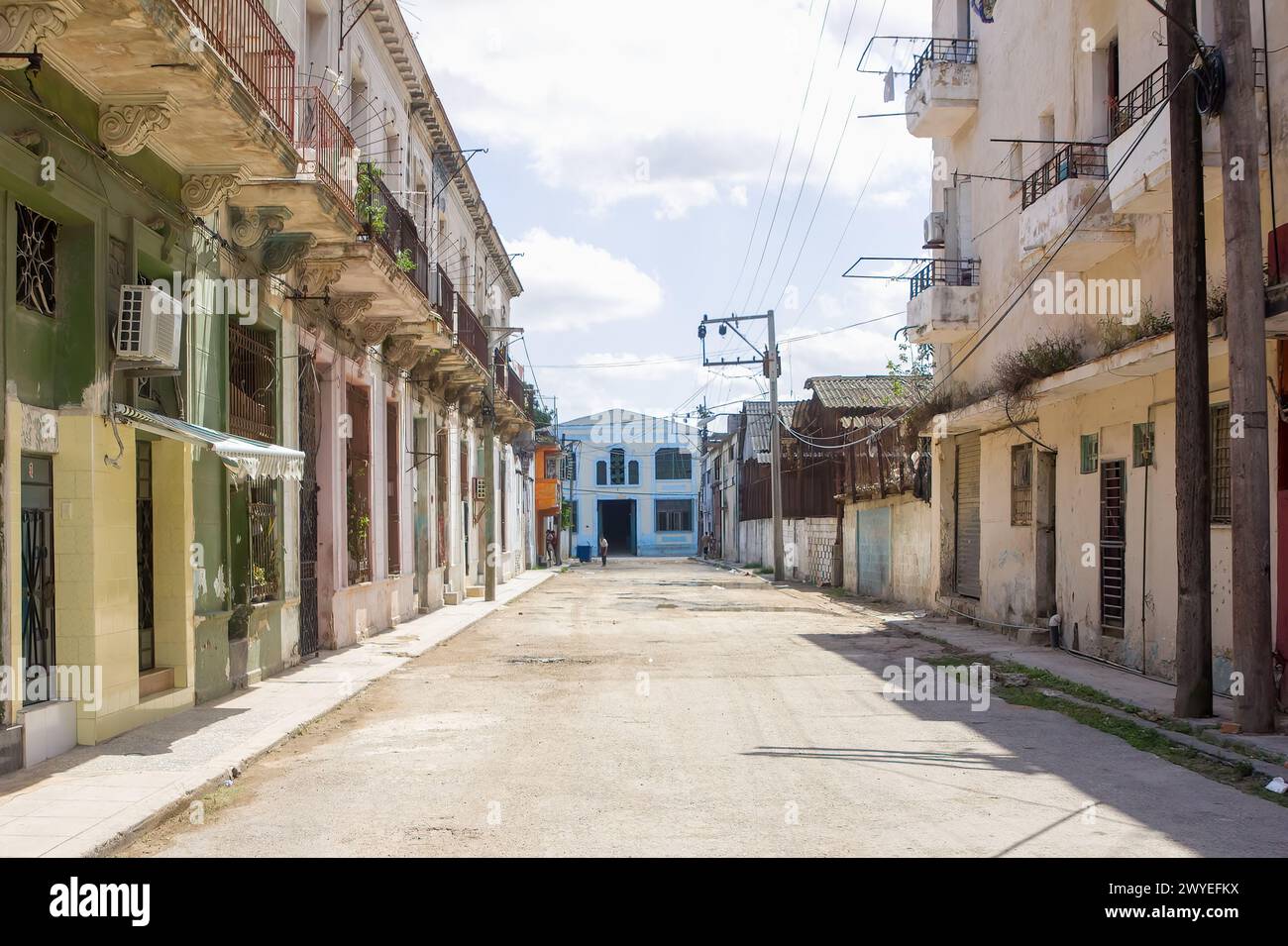 Strada vuota con scarsa manutenzione e facciata di edifici rovinati a l'Avana, Cuba Foto Stock