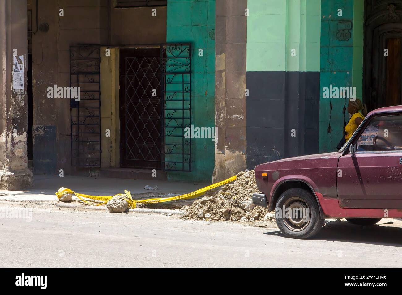 Una vecchia macchina Lada parcheggiata da un mucchio di macerie in una strada di città a l'Avana, Cuba Foto Stock