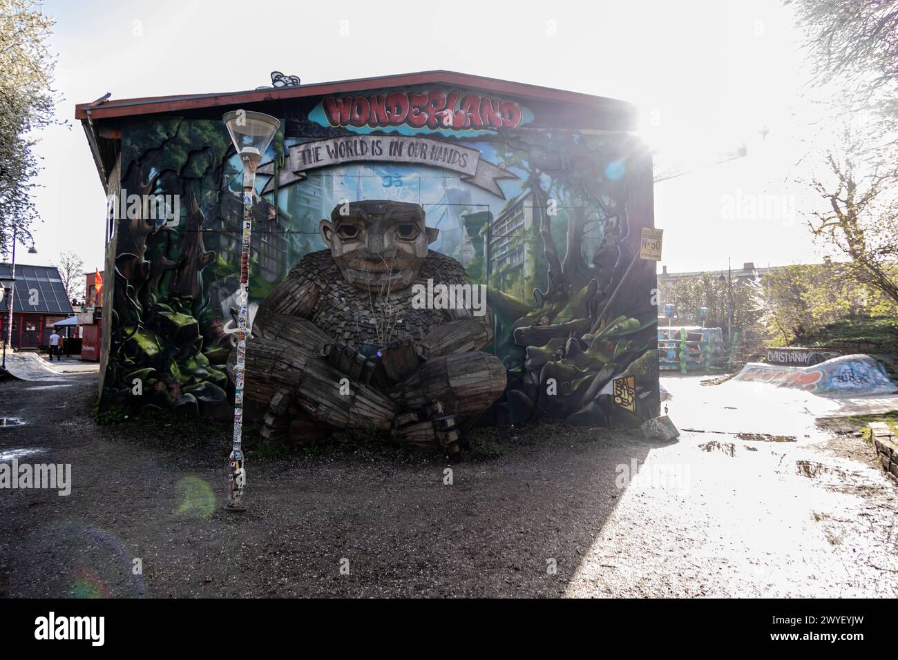 Una gigantesca scultura di troll in legno Green George realizzata da Thomas Dambo posta di fronte a un muro con graffiti o murales visti al Freetown Christiania il 6 aprile 2024 Copenhagen Freetown Christiania Danimarca Copyright: XKristianxTuxenxLadegaardxBergx 2E6A9760 Foto Stock