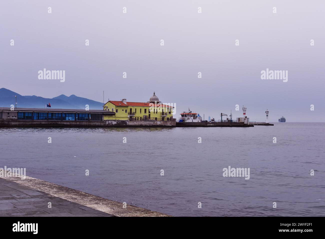 Lungomare del quartiere di Smirne Pasaport con traghetti cith e faro in mare Foto Stock