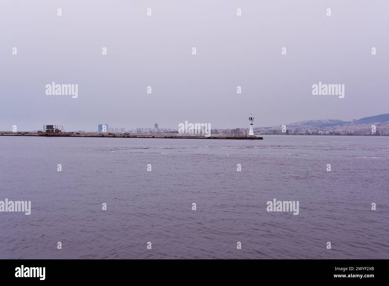 Lungomare del quartiere di Smirne Pasaport con traghetti cith e faro in mare Foto Stock