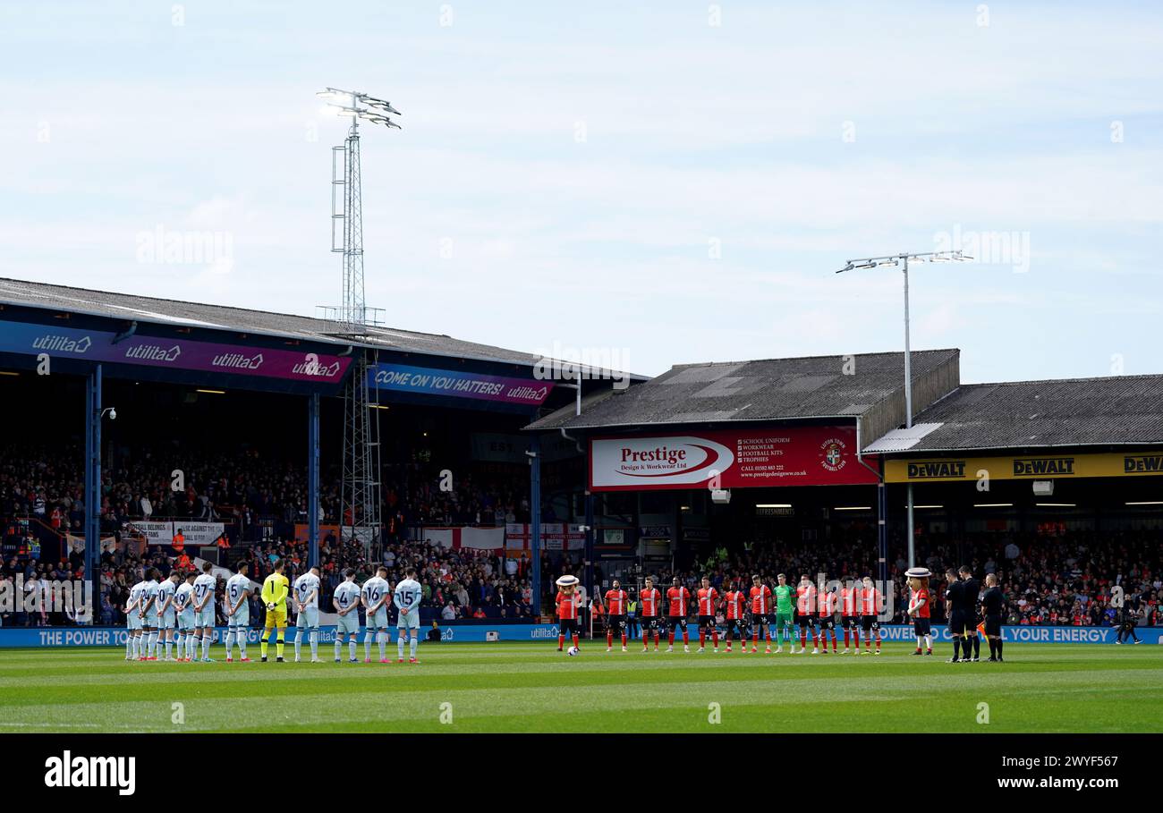 I giocatori di entrambe le squadre osservano un minuto di silenzio per quattro ex giocatori del Luton Town, Ron Baynham, Jimmy Husband, Billy Kellock e Chris Nicholl, prima della partita di Premier League a Kenilworth Road, Luton. Data foto: Sabato 6 aprile 2024. Foto Stock