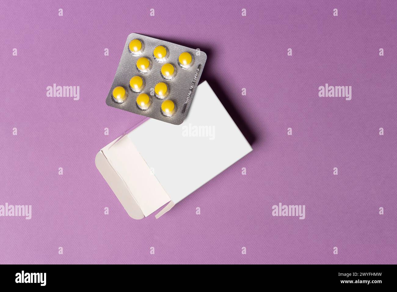 Compresse di pillole su una scatola di fronte allo sfondo viola, percorso di selezione incluso. Foto Stock