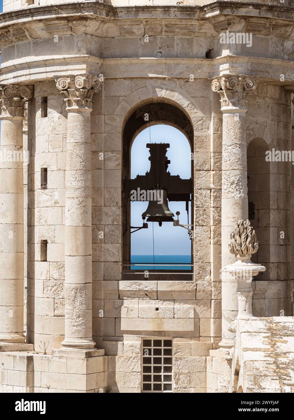 Il campanile della Cattedrale di Cadice, vista ravvicinata di una campana della chiesa cattolica, orizzonte marino con nave sullo sfondo Foto Stock