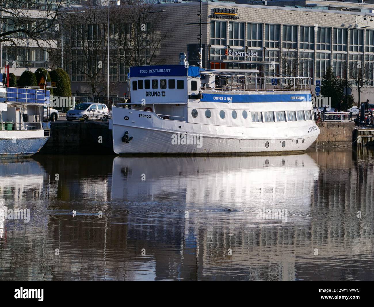 Nave ristorante sulla riva del fiume Aura al sole primaverile, Turku Finlandia Foto Stock