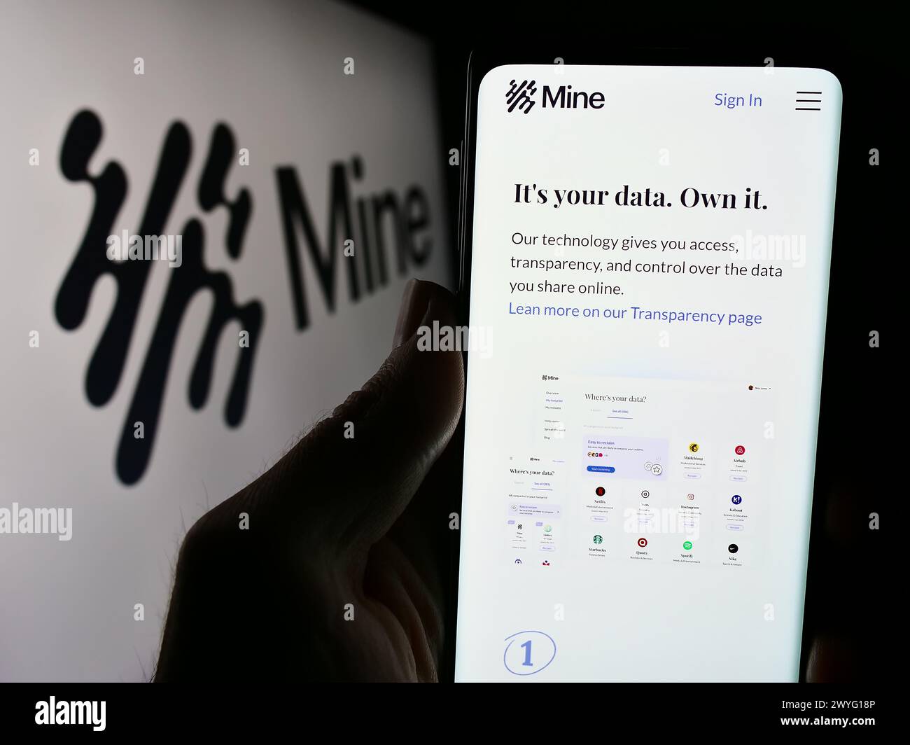 Persona che detiene lo smartphone con la pagina Web della società del sistema operativo Saymine Technologies Ltd. (Mio) con logo. Messa a fuoco al centro del display del telefono. Foto Stock