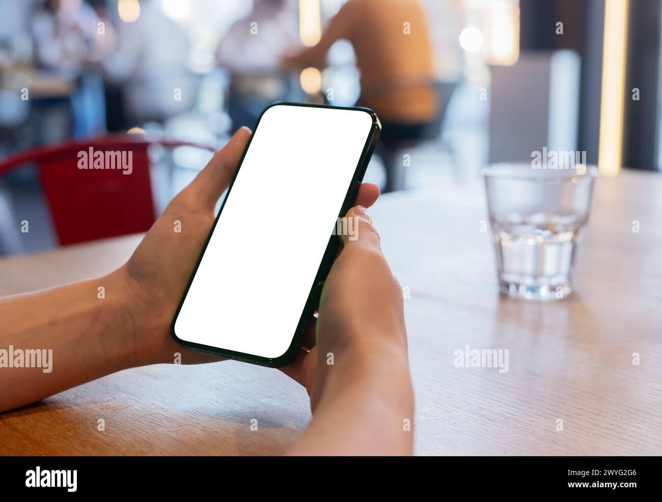Una donna ha uno smartphone, mostrando uno schermo vuoto. Perfetto per la pubblicità digitale o la visualizzazione di app. Foto Stock