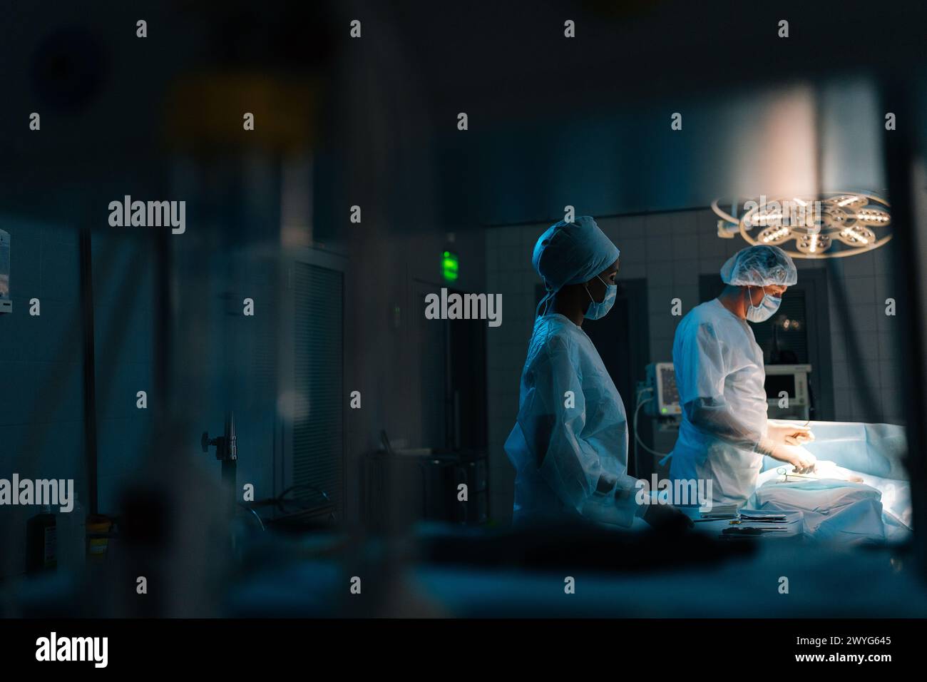 Visualizzazione remota di chirurghi professionisti in un intervento chirurgico di trapianto cardiaco con esecuzione uniforme sotto lampade luminose utilizzando strumenti medici in Foto Stock