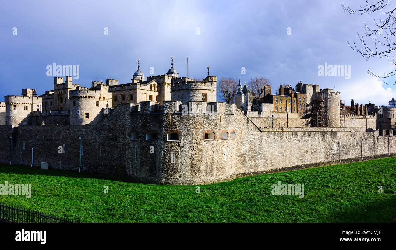 Vista panoramica esterna delle mura e delle torri della Torre di Londra sotto il cielo scuro Foto Stock