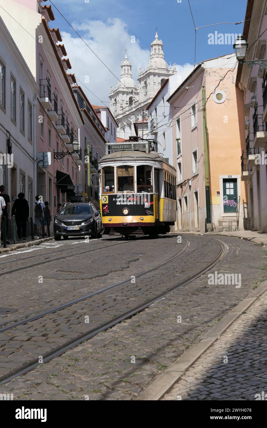 Il famoso tram giallo attraversa i quartieri più antichi, Lisbona, Portogallo. Il tram giallo è molto popolare tra i turisti. Foto Stock