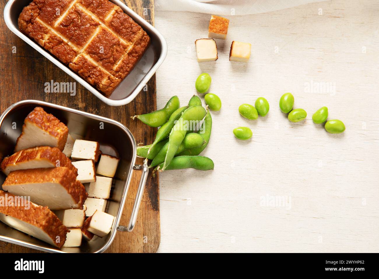 Cibo di soia. Tofu al forno su tavola, semi di soia. Prodotto vegano. Vista dall'alto, copia spazio Foto Stock
