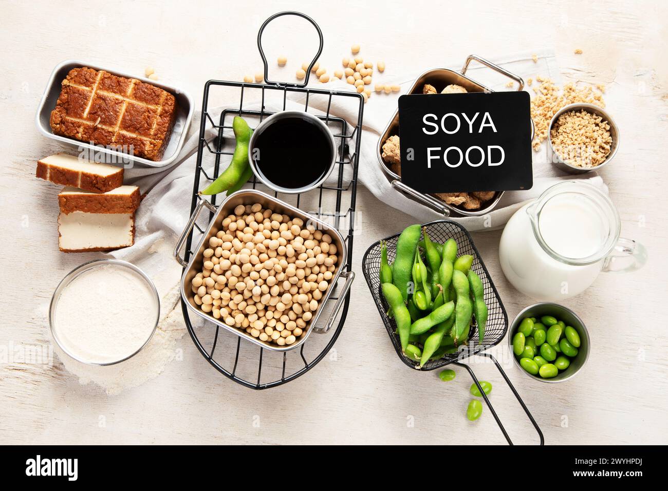 Vari prodotti di soia con semi di soia, tofu, salsa di soia e latte di soia su sfondo chiaro. Vista dall'alto Foto Stock