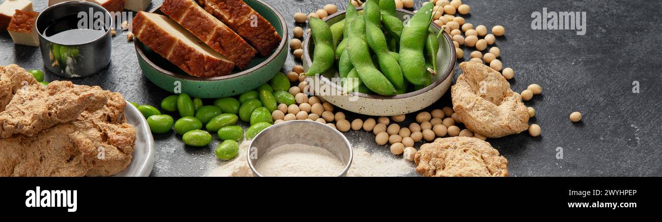 Prodotti di soia su sfondo nero. Cibo sano vegano. Vista dall'alto, spazio copia, banner Foto Stock