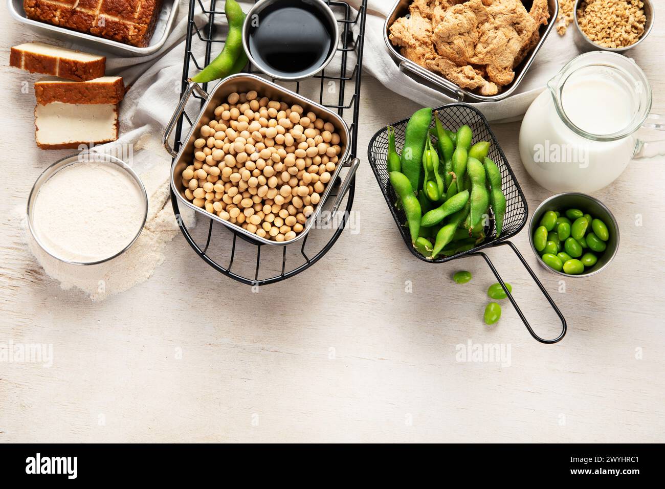 Vari prodotti di soia con semi di soia, tofu, salsa di soia e latte di soia su sfondo chiaro. Vista dall'alto. Copia spazio. Foto Stock
