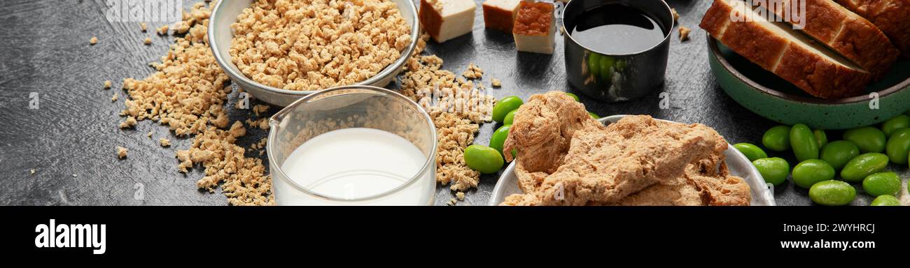Prodotti di soia su sfondo scuro. Cibo sano vegano. Vista dall'alto, spazio copia, banner Foto Stock