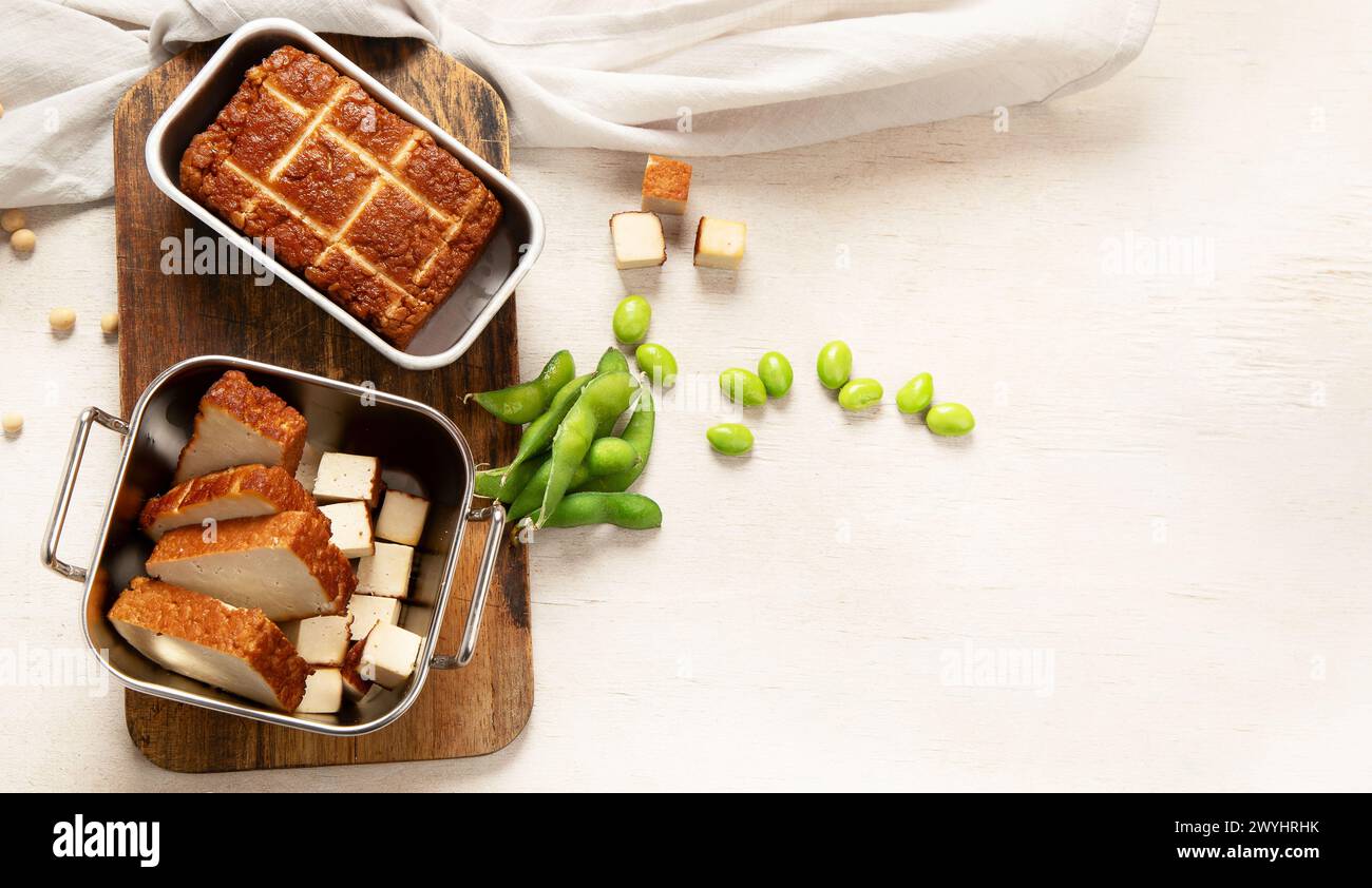 Cibo di soia. Tofu al forno su tavola, semi di soia. Prodotto vegano. Vista dall'alto, copia spazio Foto Stock