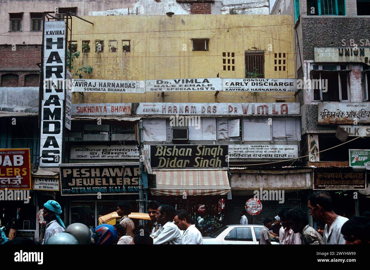 Cartelli pubblicitari e negozi, presi nel 1992, quartiere di Old Delhi, nuova Delhi, India Foto Stock