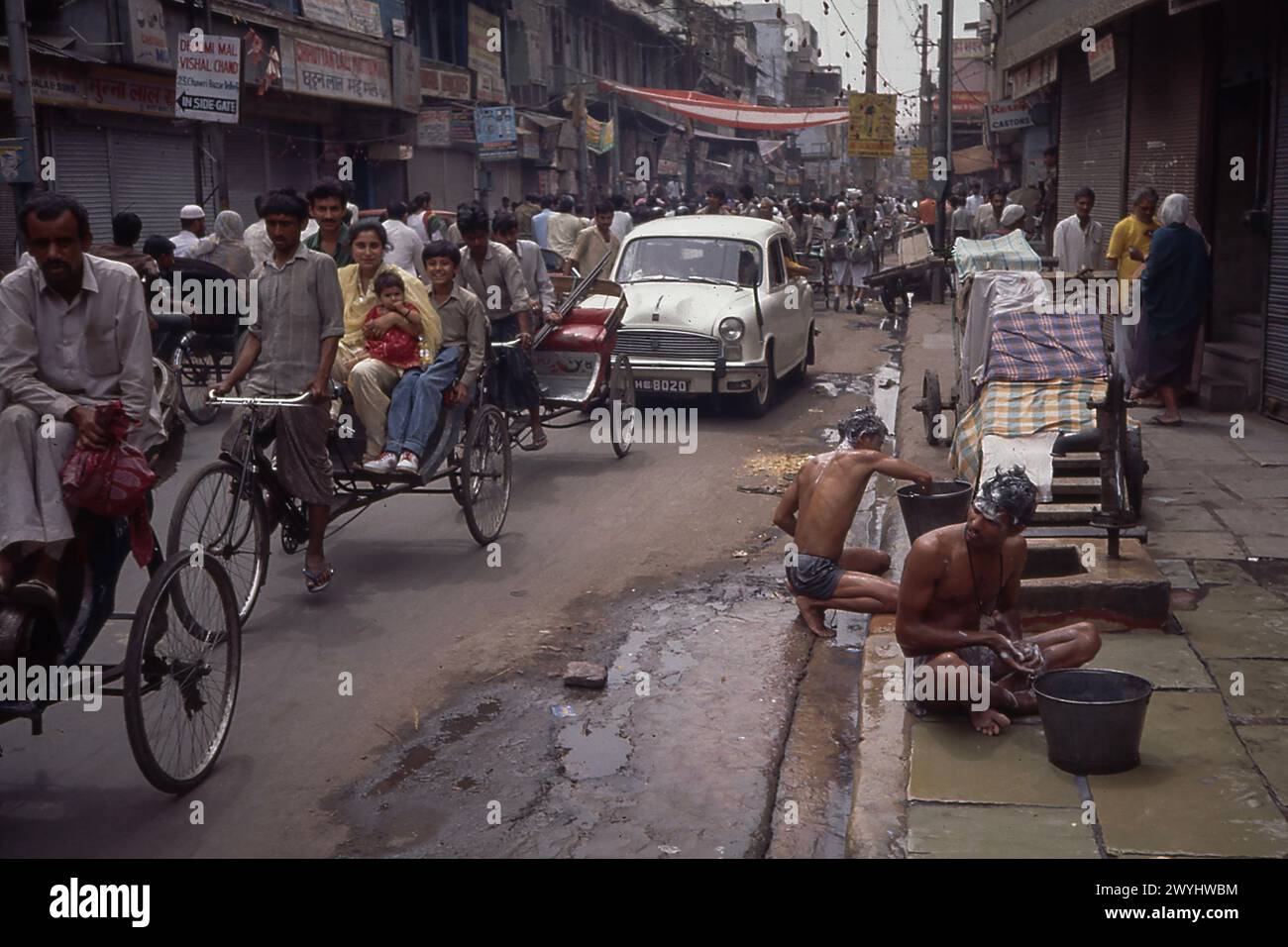 Uomini che si lavano in grondaia per strada, presi nel 1992, quartiere di Old Delhi, nuova Delhi, India Foto Stock