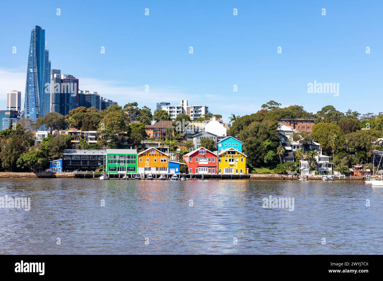 Gli edifici colorati del molo Waterview sulla penisola di Balmain con il grattacielo Crown Casino e gli alti edifici di Sydney in lontananza Foto Stock