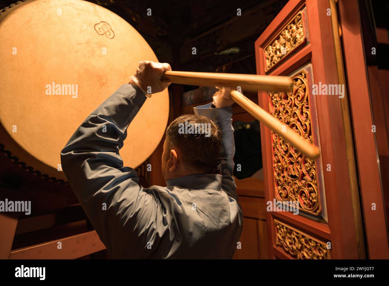 Uomo che suona il tamburo tradizionale durante la cerimonia di Capodanno al tempio di Dalongdong Baoan Foto Stock