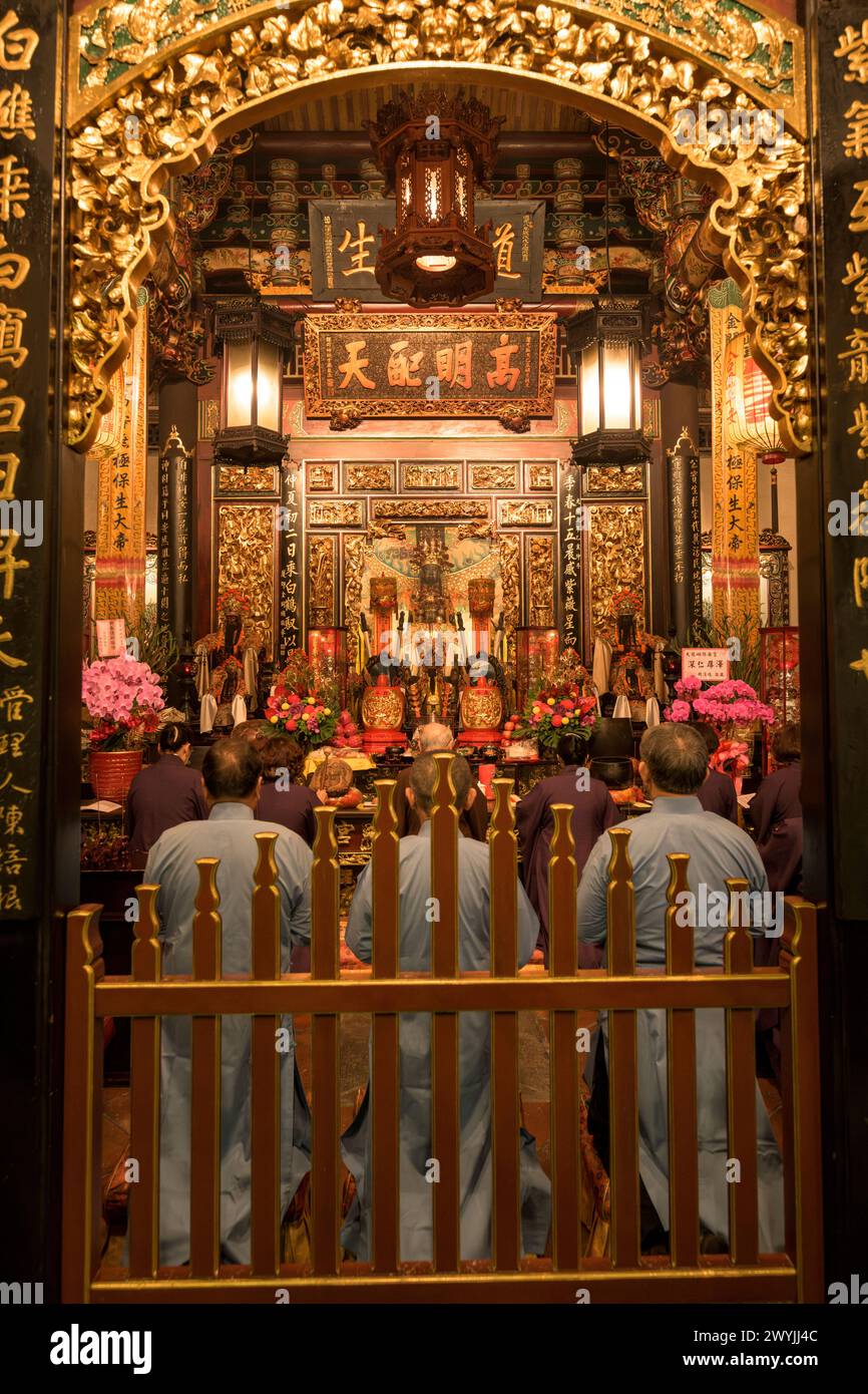 Devoti con offerte durante una cerimonia religiosa per il Capodanno cinese nel tempio Baoan Foto Stock
