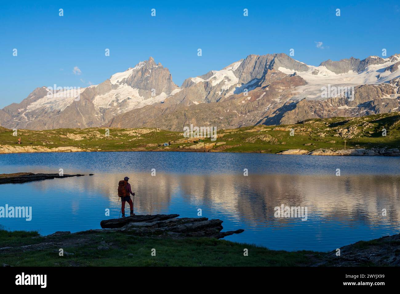 Francia, Hautes-Alpes, la grave, altopiano di Emparis, escursionista ai margini del Lac Noir (2435 m), sullo sfondo le creste della parete nord del Meije (3983 m), il Râteau (3809 m) e il ghiacciaio del Girose nel Parco Nazionale degli Ecrins Foto Stock