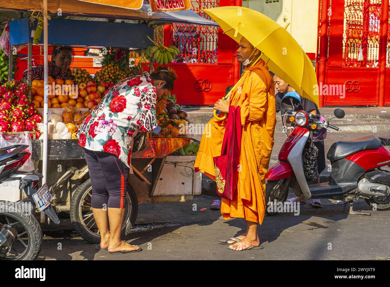 Cambogia, Phnom Penh, monaco buddista che riceve l'elemosina dai fedeli ogni mattina Foto Stock