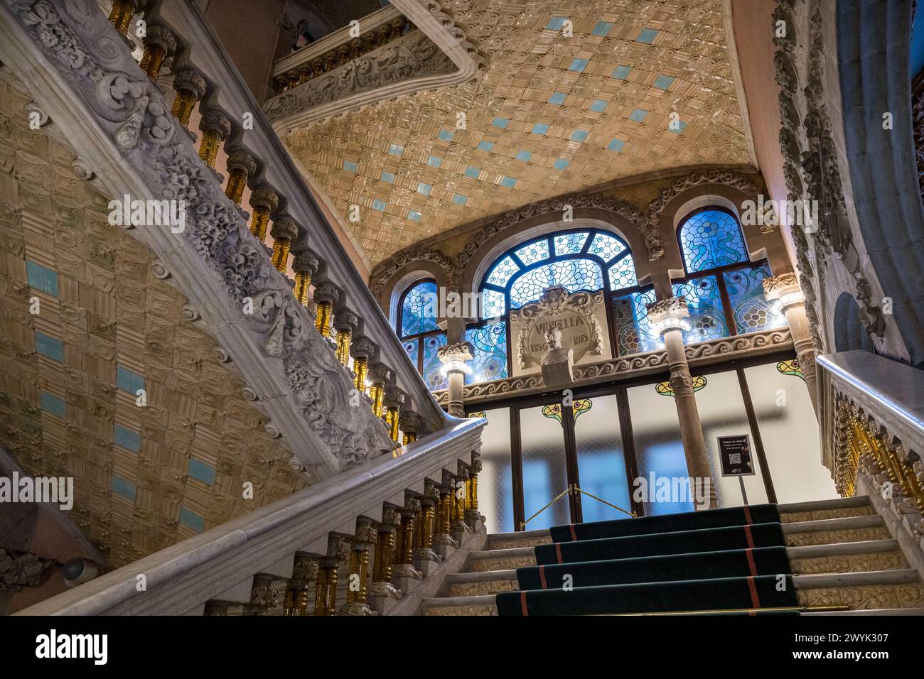 Spagna, Catalogna, Barcellona, Palau de la musica Catalana, sala concerti progettata dall'architetto del modernismo catalano Lluis Domènech i Montaner, sito patrimonio dell'umanità dell'UNESCO, vestibolo, il banister delle scale in pietra finemente lavorata e sostenuto da balaustre in vetro giallo trasparente Foto Stock